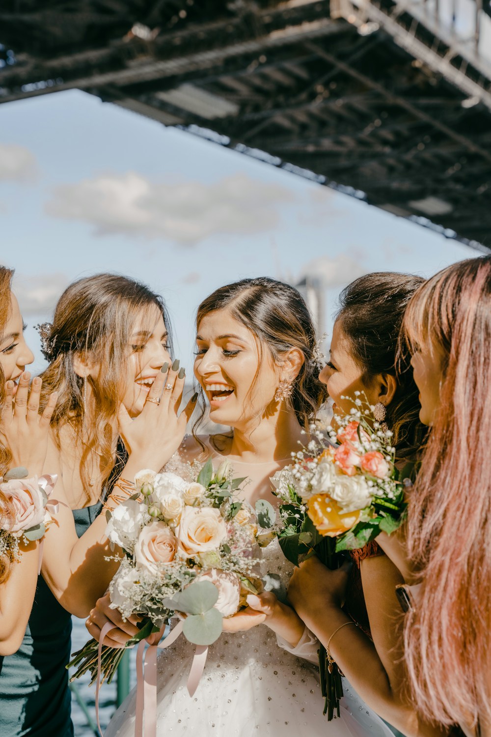 Bride laughing with her bridesmaids
